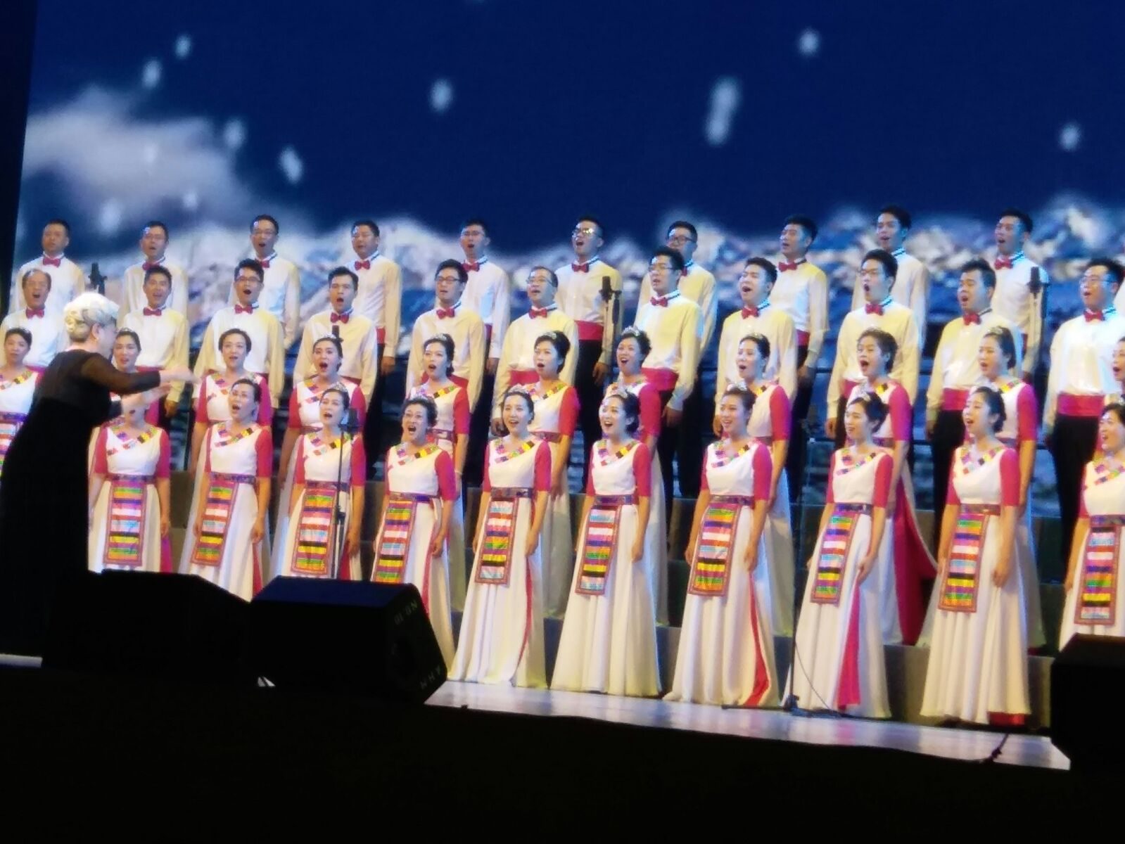 Coral em apresentação durante festival com público em teatro